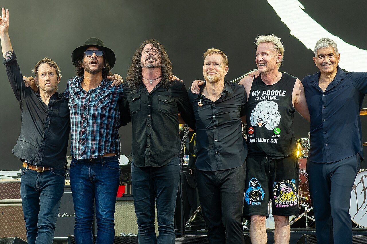 The members of Foo Fighters standing together on stage in 2023