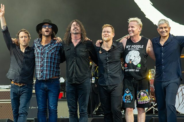 The members of Foo Fighters standing together on stage in 2023