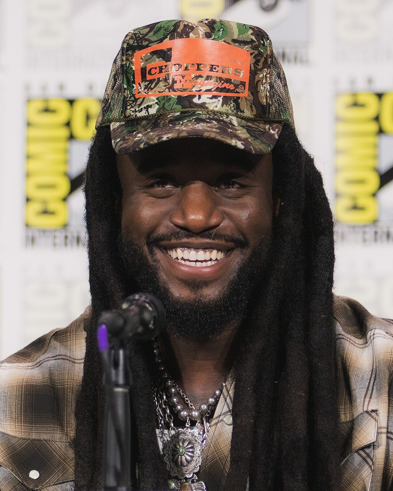 Shaboozey smiling in a camouflage cap at San Diego Comic-Con in 2026