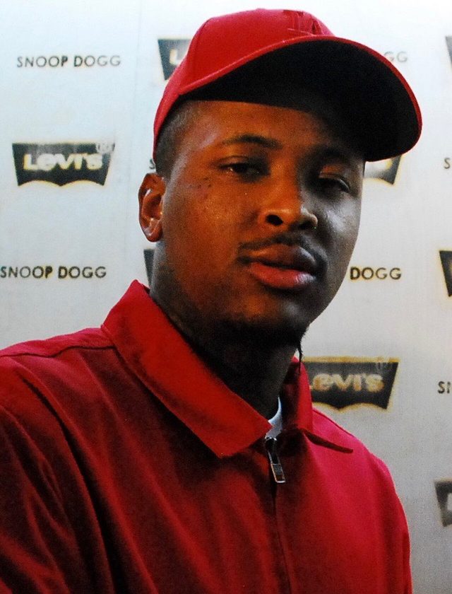 YG in a red cap and red jacket at a 2015 event